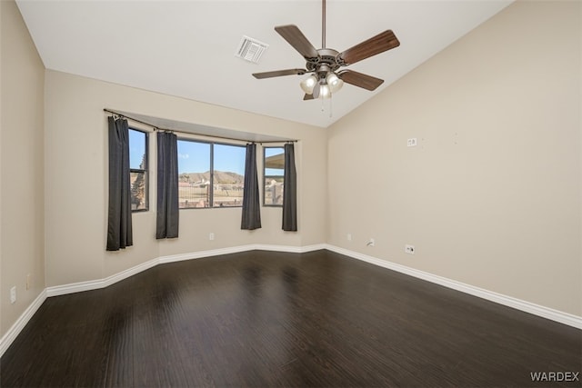 spare room with baseboards, visible vents, lofted ceiling, ceiling fan, and wood finished floors