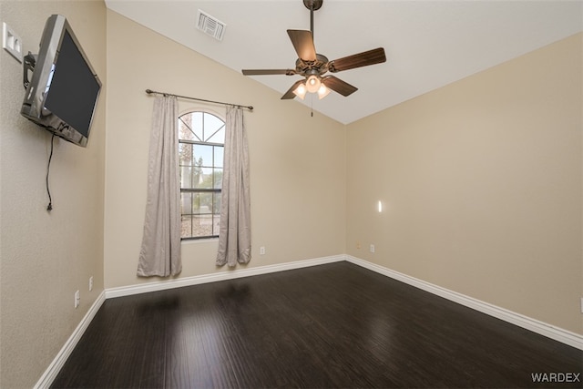 empty room with lofted ceiling, baseboards, visible vents, and wood finished floors