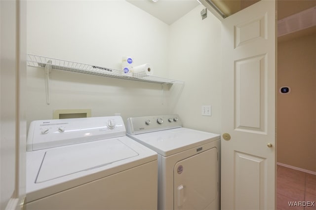 laundry area featuring laundry area, washing machine and clothes dryer, and tile patterned floors