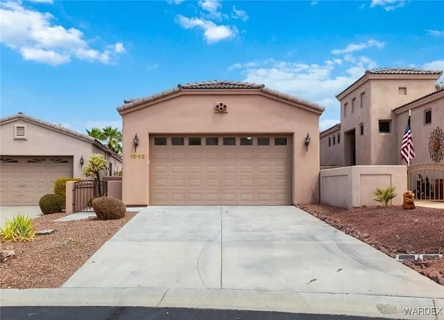 mediterranean / spanish-style house featuring stucco siding, an outdoor structure, concrete driveway, and fence