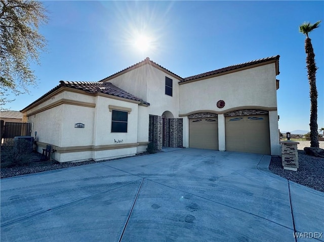 view of side of home with a garage, a tile roof, concrete driveway, and stucco siding