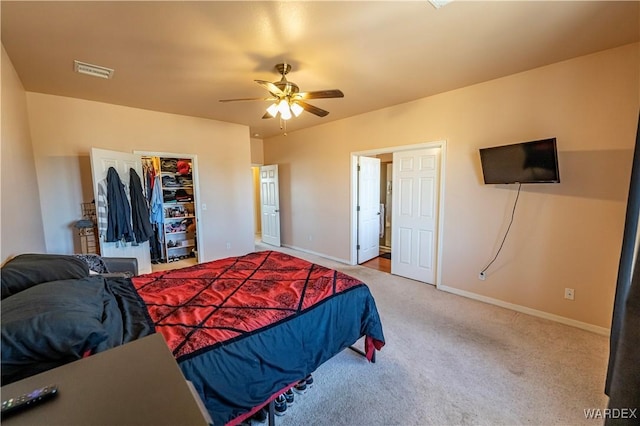 carpeted bedroom with baseboards, visible vents, a ceiling fan, a spacious closet, and a closet