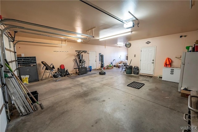 garage featuring a garage door opener and freestanding refrigerator