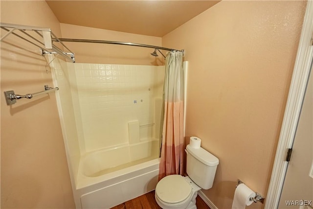 bathroom featuring wood finished floors, toilet, and shower / tub combo with curtain