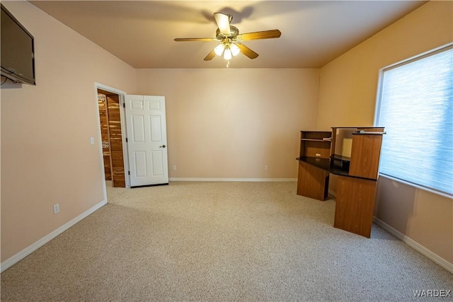 empty room featuring light carpet, baseboards, and a ceiling fan