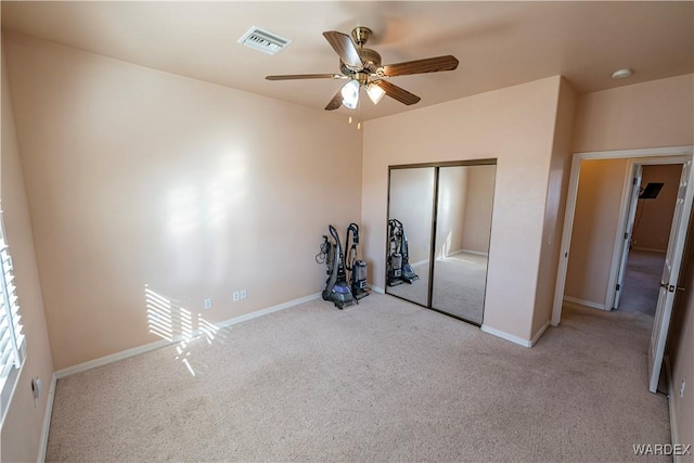 unfurnished bedroom with carpet floors, a closet, visible vents, a ceiling fan, and baseboards