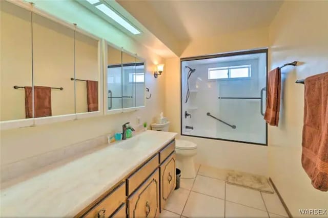 full bathroom featuring toilet, combined bath / shower with glass door, vanity, and tile patterned floors