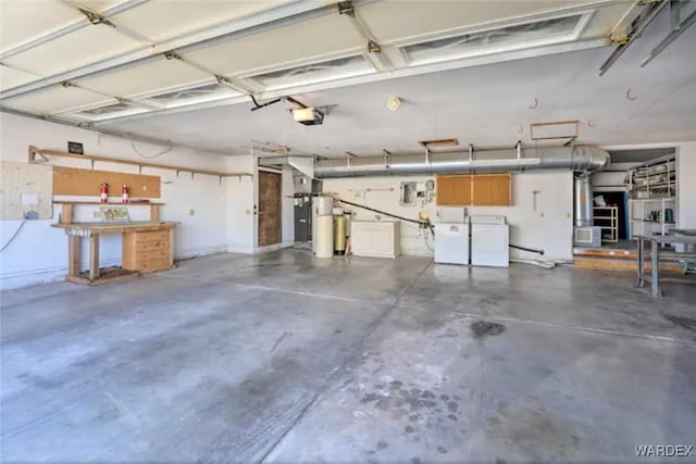 garage featuring a garage door opener, strapped water heater, and independent washer and dryer