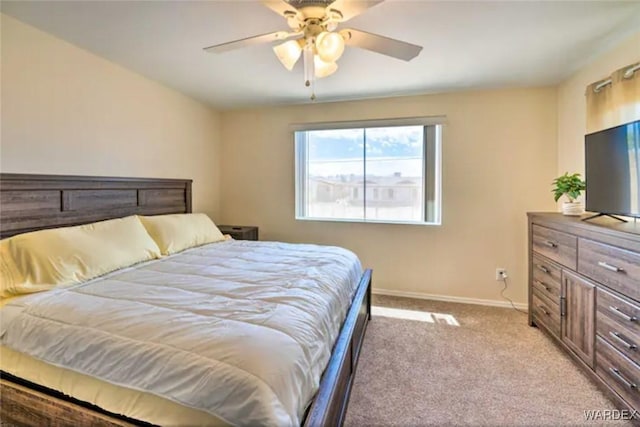 bedroom with light carpet, ceiling fan, and baseboards