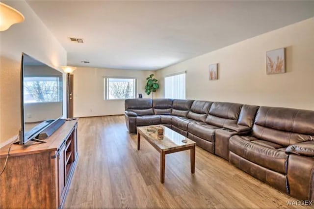 living area featuring light wood-style flooring and visible vents