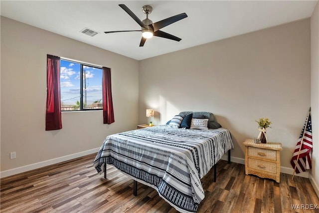 bedroom featuring ceiling fan, wood finished floors, visible vents, and baseboards