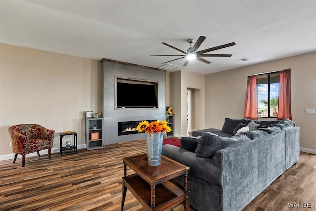 living room with baseboards, visible vents, dark wood-style floors, ceiling fan, and a fireplace