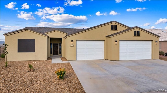 single story home with an attached garage, driveway, a tile roof, and stucco siding