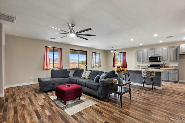 living area featuring dark wood-style floors, baseboards, visible vents, and recessed lighting