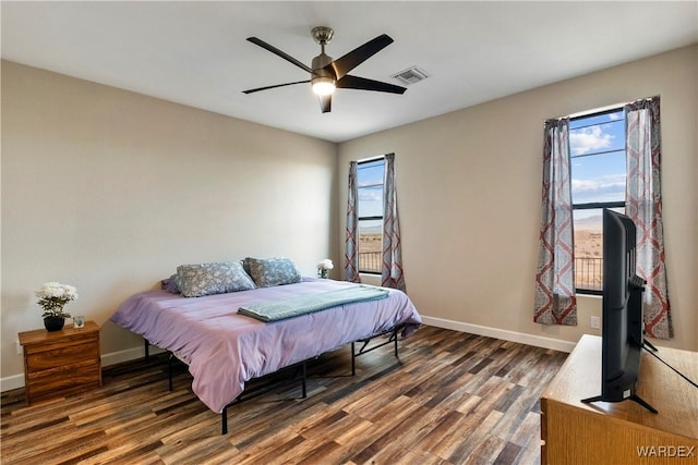 bedroom with baseboards, multiple windows, visible vents, and dark wood-style flooring