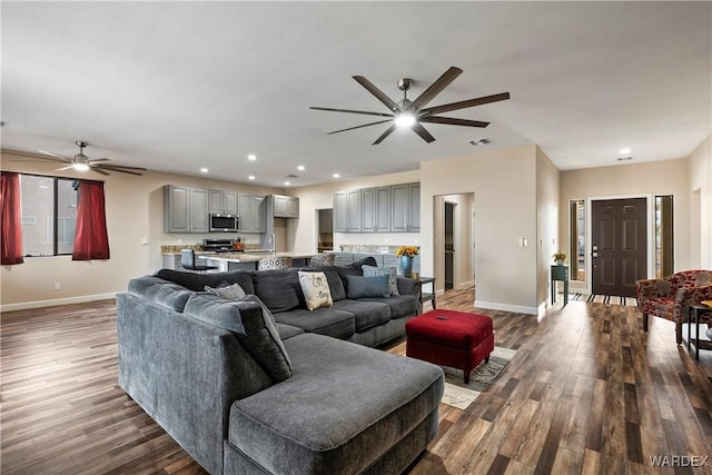 living area with dark wood-style floors, baseboards, visible vents, and recessed lighting