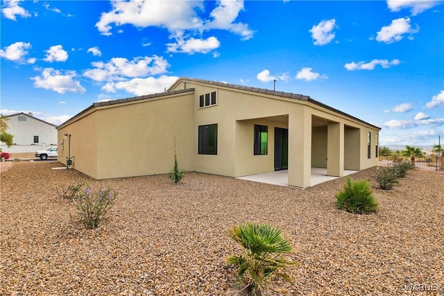 rear view of property featuring a patio area and stucco siding