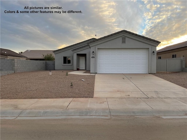 4933 N Famoso Dr, Kingman, AZ 86409 - ranch-style house featuring a garage, fence, driveway, and stucco siding