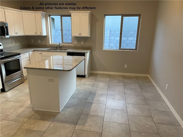 4933 N Famoso Dr, Kingman, AZ 86409 - kitchen featuring stainless steel appliances, a sink, light stone countertops, white cabinetry, and a kitchen island
