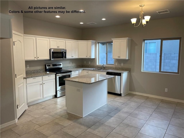 4933 N Famoso Dr, Kingman, AZ 86409 - kitchen featuring appliances with stainless steel finishes, a sink, white cabinetry, light stone countertops, and a chandelier