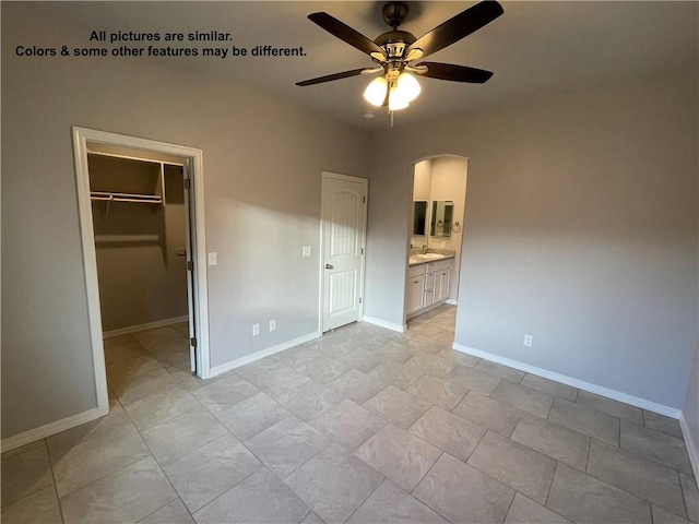 4933 N Famoso Dr, Kingman, AZ 86409 - unfurnished bedroom featuring arched walkways, a spacious closet, baseboards, and a closet