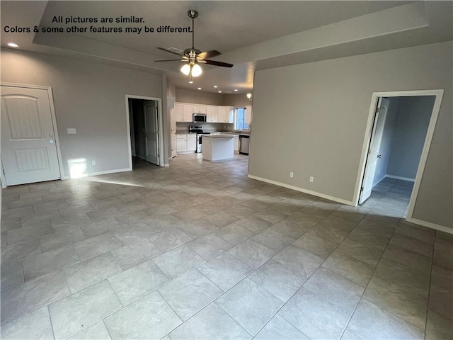 4933 N Famoso Dr, Kingman, AZ 86409 - unfurnished living room featuring ceiling fan, baseboards, a tray ceiling, and recessed lighting