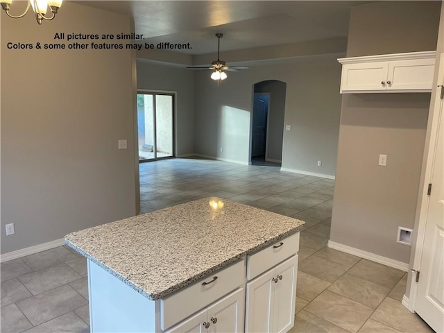 4933 N Famoso Dr, Kingman, AZ 86409 - kitchen featuring arched walkways, ceiling fan, light tile patterned floors, and a kitchen island