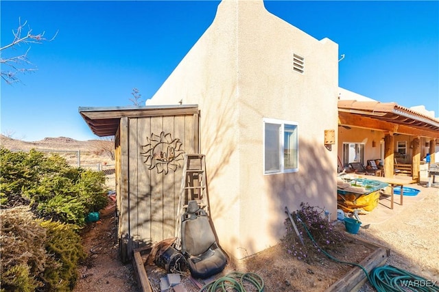 back of property featuring a patio area, a mountain view, and stucco siding