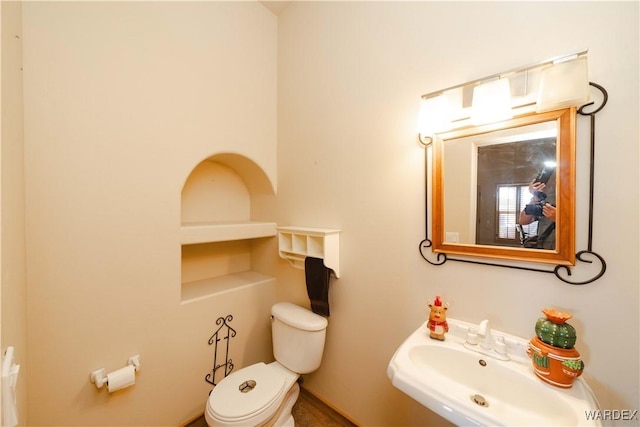 half bath featuring a sink and toilet