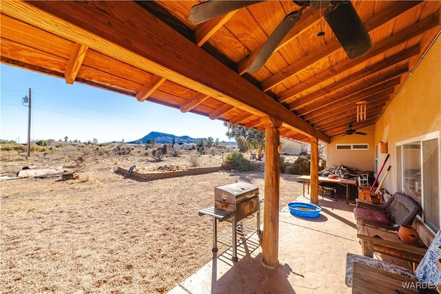 view of patio / terrace featuring a ceiling fan and a mountain view