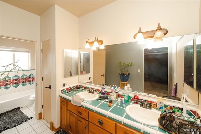 full bathroom featuring a washtub, tile patterned flooring, a sink, and toilet