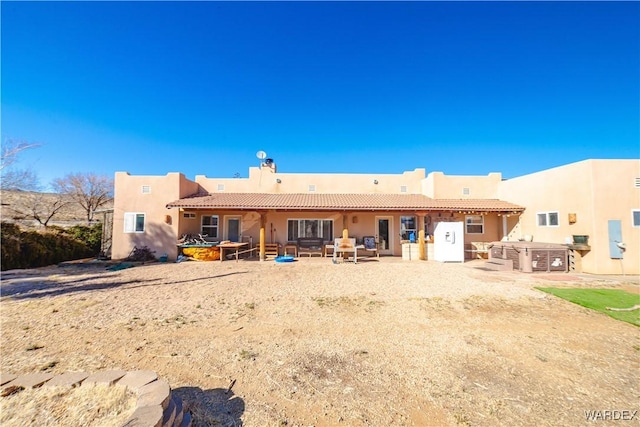 back of house featuring exterior kitchen, a patio area, a tile roof, and stucco siding