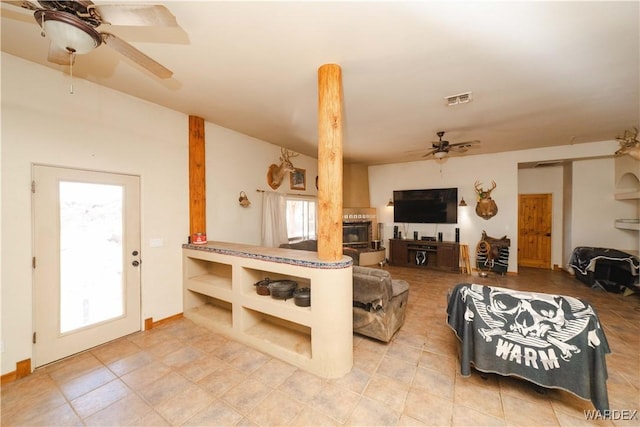 living area with light tile patterned floors, ceiling fan, and visible vents