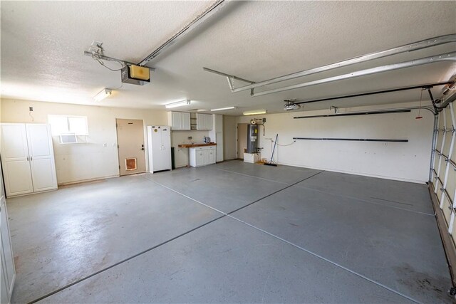 2198 E Valley View Rd, Kingman, AZ 86409 - garage with a garage door opener, water heater, and freestanding refrigerator