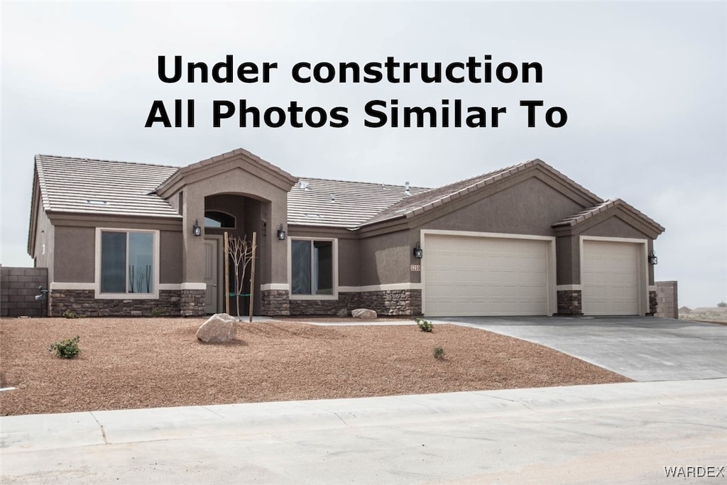 exterior space featuring a garage, stone siding, driveway, and stucco siding