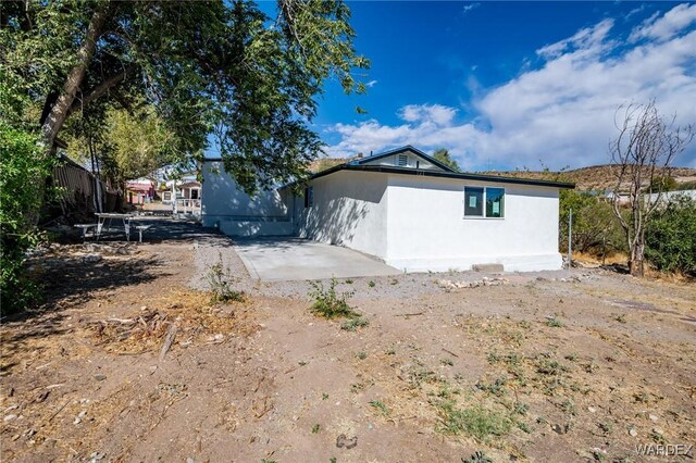 exterior space featuring stucco siding, fence, and a patio