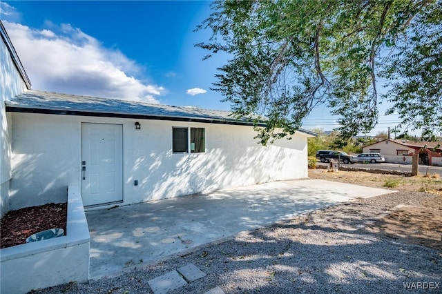 view of side of home with a patio and stucco siding