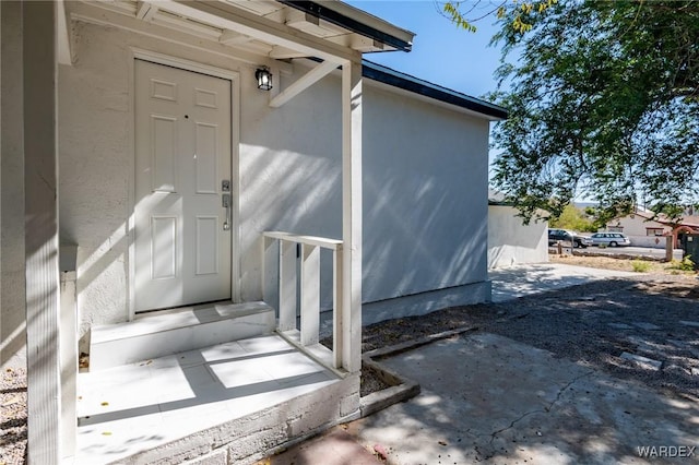 entrance to property featuring stucco siding