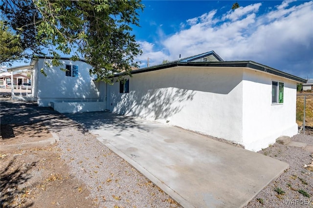 view of side of home featuring a patio area and stucco siding