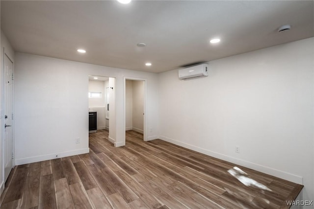 interior space featuring a wall unit AC, wood finished floors, and recessed lighting