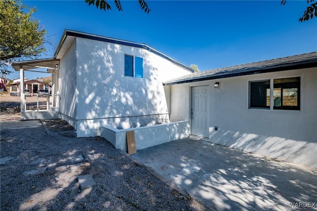 view of side of property with a patio area and stucco siding