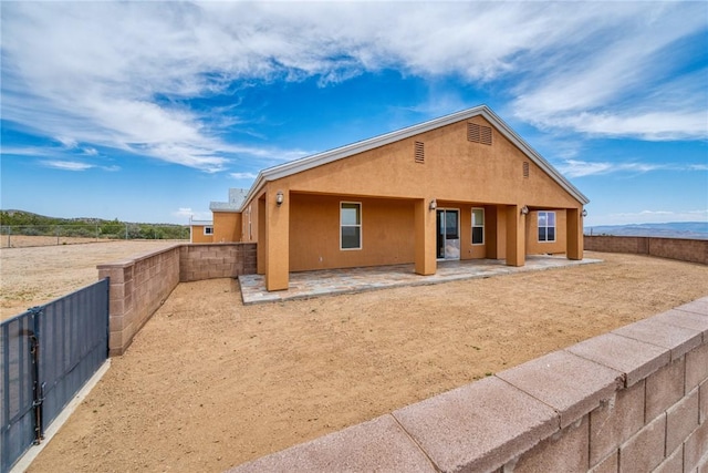 9076 E Mountain Shadow Rd, Kingman, AZ 86401 - view of front of house with a patio, stucco siding, and a fenced backyard