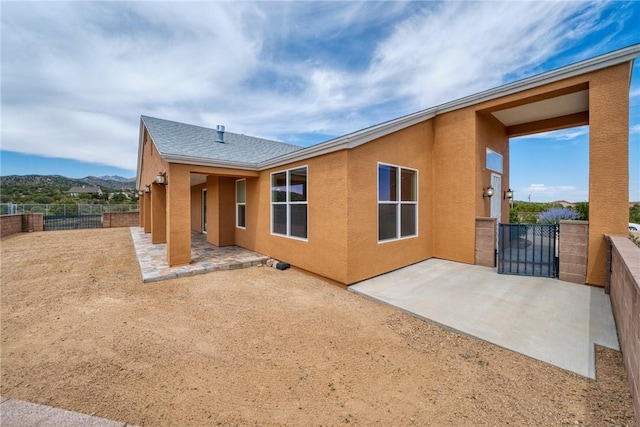 9076 E Mountain Shadow Rd, Kingman, AZ 86401 - rear view of house featuring a patio, stucco siding, a fenced backyard, and a shingled roof
