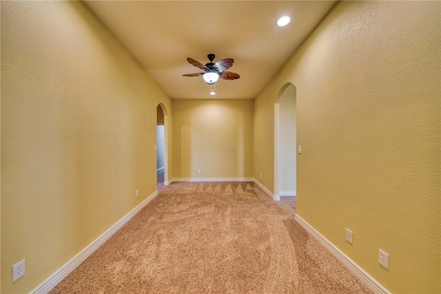 9076 E Mountain Shadow Rd, Kingman, AZ 86401 - unfurnished room featuring arched walkways, a ceiling fan, light colored carpet, baseboards, and recessed lighting