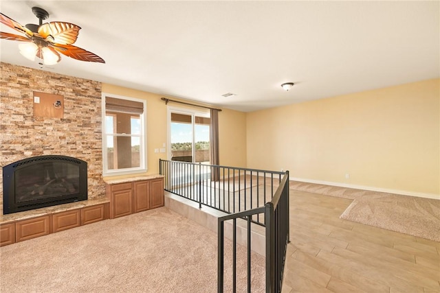 9076 E Mountain Shadow Rd, Kingman, AZ 86401 - unfurnished living room featuring ceiling fan, a glass covered fireplace, light wood-type flooring, and baseboards
