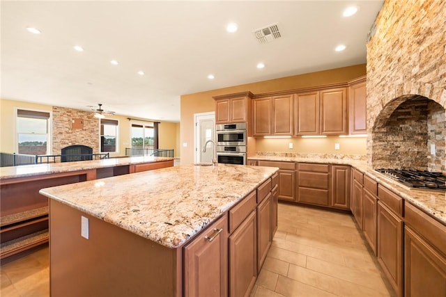 9076 E Mountain Shadow Rd, Kingman, AZ 86401 - kitchen featuring a stone fireplace, appliances with stainless steel finishes, a sink, an island with sink, and recessed lighting