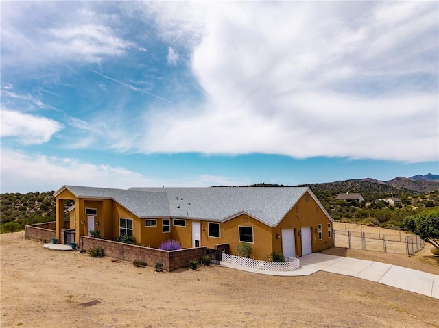 9076 E Mountain Shadow Rd, Kingman, AZ 86401 - view of front of house with a garage, concrete driveway, stucco siding, and a mountain view