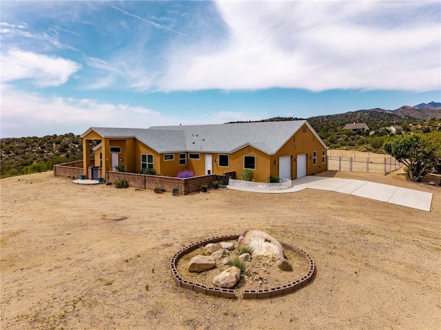 9076 E Mountain Shadow Rd, Kingman, AZ 86401 - view of front of house with an attached garage, concrete driveway, and a mountain view