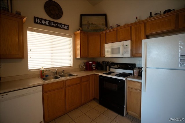 kitchen with light countertops, white appliances, brown cabinetry, and a sink