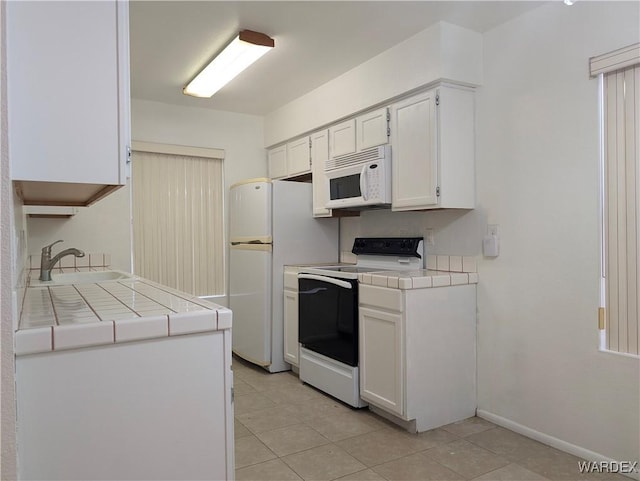 1280 Mohave Dr Unit 13, Bullhead City, AZ 86442 - kitchen with a sink, white cabinetry, white appliances, light tile patterned floors, and tile counters